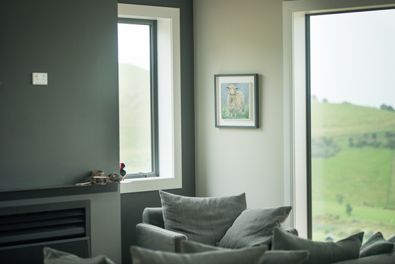 Picture of a modern living room with gray walls and white windows